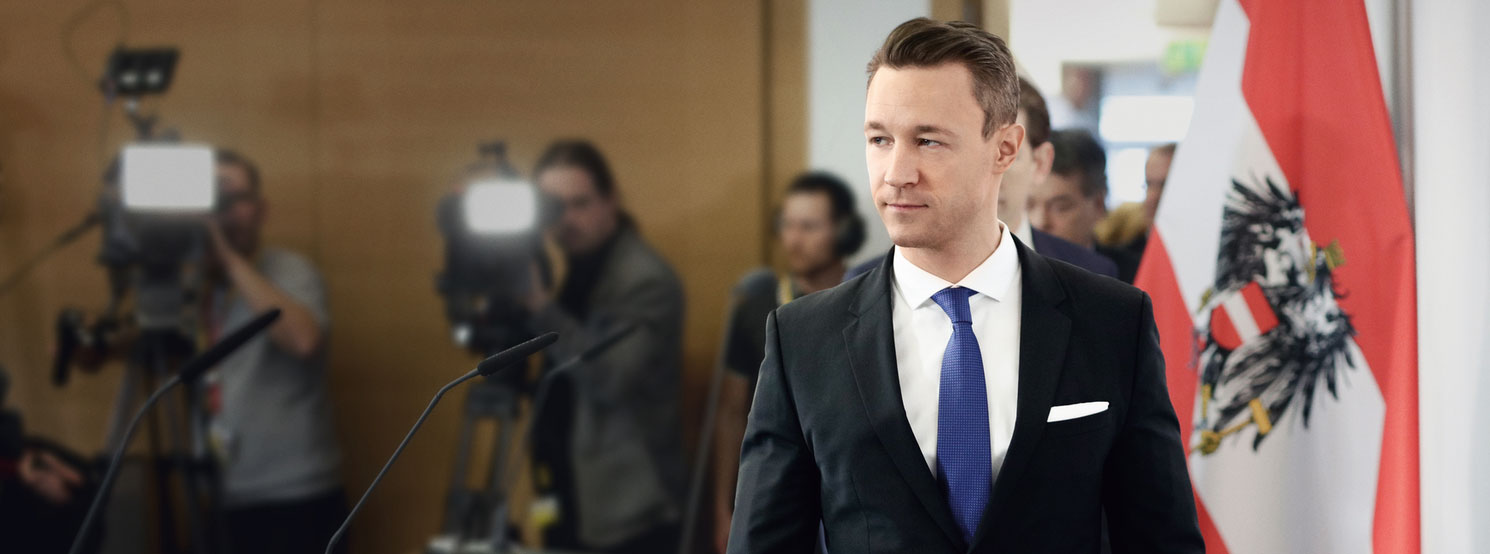 Gernot geht beschäftigt durch einen Korridor
